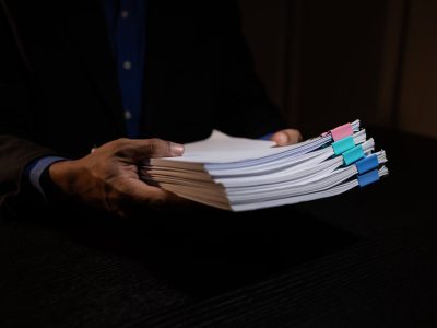 Pracownik niesie dokumenty do utylizacji w firmie w Ostródzie