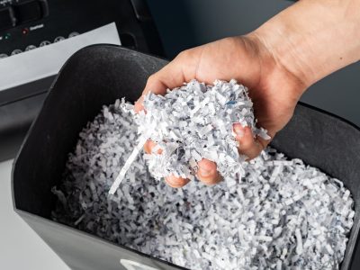 Male hand holding a bunch of shredded paper close up